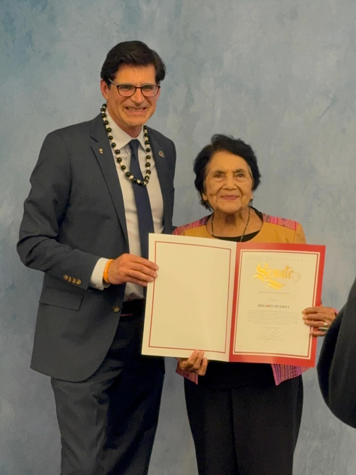 Senator Becker presenting a certificate to Dolores Huerta.