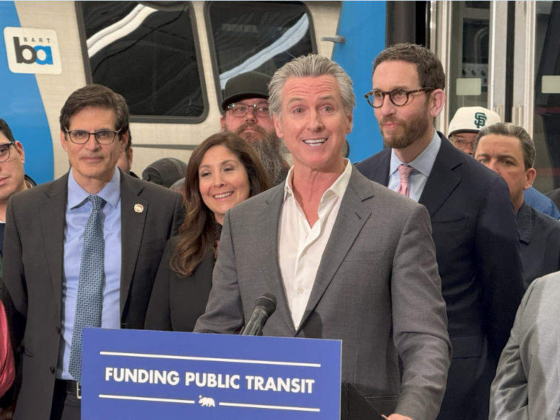 Senator Becker with Governor Newsom, legislators, transit agencies and operators, and labor representatives for the bill signing of AB 117. 